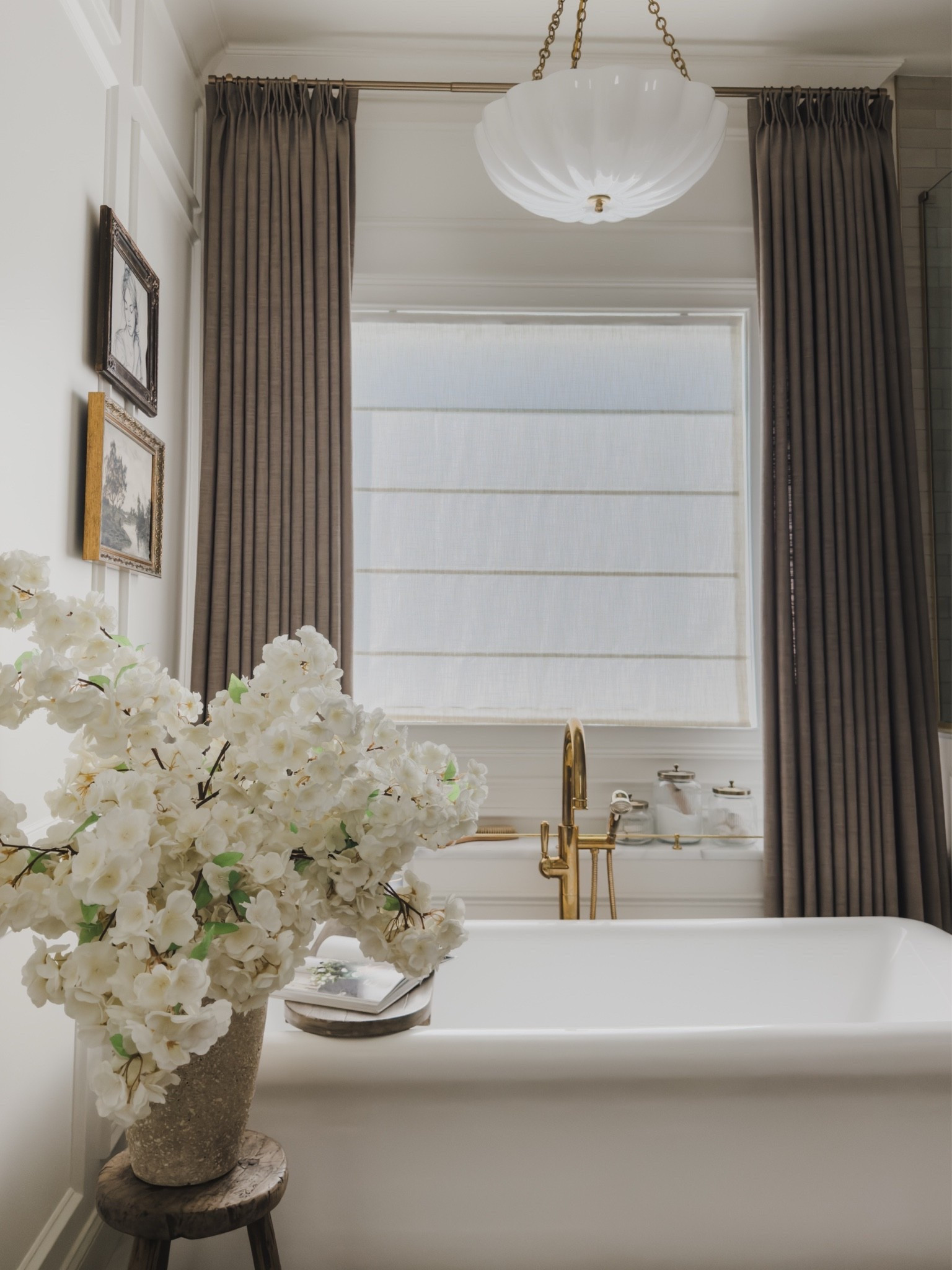 One of my favorite primary bathroom views with a modern yet timeless acrylic tub and my moody pinch pleat curtains that truly elevate the look. Paired with brass details and statement light that gives all the luxe vibes.

Home finds, neutral home inspo, primary bathroom refresh, collected style, summer refresh, early fall transition, pinch pleat curtain, linen shade, faux florals, gallery wall, brass details, tub details, tub caddy, statement lighting, Wayfair, Visual Comfort, Afloral, tub filler, Two Pages, McGee and Co, shop the look!

#LTKSeasonal #LTKHome