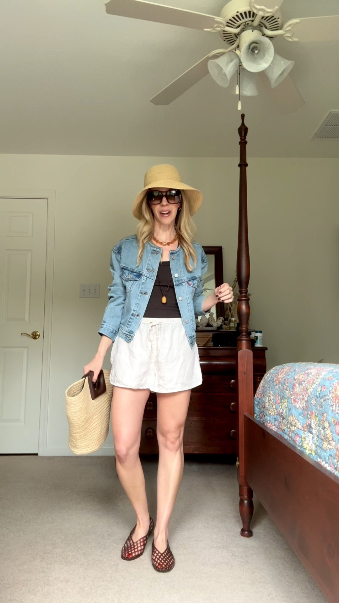 Casual summer outfit, cropped denim jacket, linen shorts styled with jelly shoes, @Janessa Leone straw bucket hat