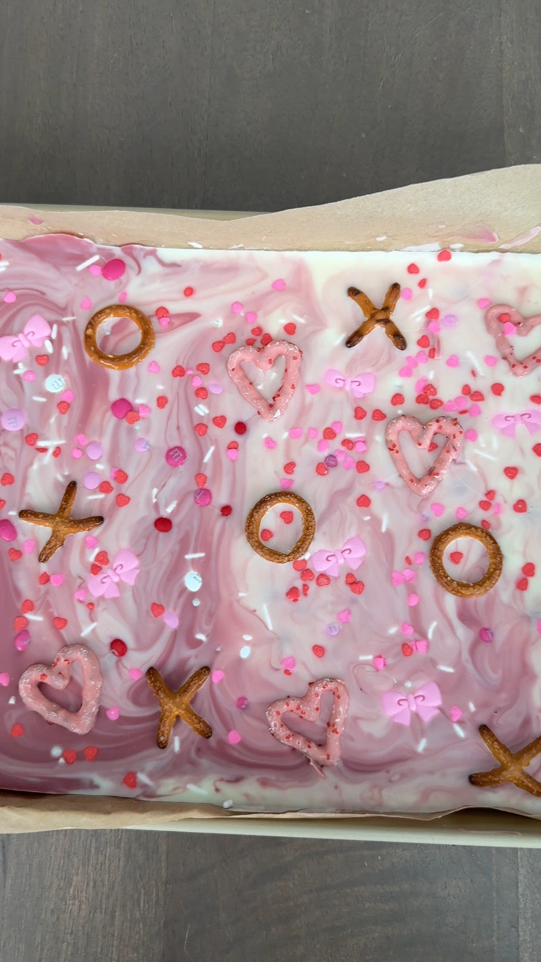 Valentine bark♥️🩷The candy bows are my favorite part!! Give to coworkers, neighbors, teachers or friends♥️ This treat was seriously so good & fun to make! Save & share with someone you want to make this with!
•
DIRECTIONS:
1. Lay out chocolate bars on parchment paper on your cookie sheet. Bake in the oven at your lowest setting for 5-8 minutes.
2. Take a toothpick or skewer and mix the chocolates together while still warm so that it begins to swirl. Top with sprinkles, pretzels & other toppings.
3. Freeze for 1-2 hours and gently break apart. Best if stored in refrigerator! 
•
•
#valentinesdaygift #vdaygift #easygift #valentinestreats #easyrecipe #easydessert #valentinesdessert #chocolatebark #valentinechocolate #asmrfood #ltkseasonal #ltkparties 

#LTKParties #LTKSeasonal