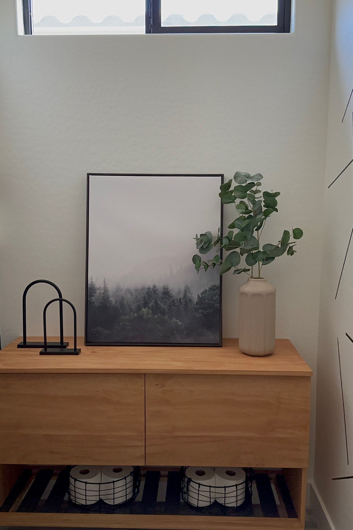 Console table styling using framed canvas art, vase, faux greenery and black metal baskets for storage. 

#LTKhome
