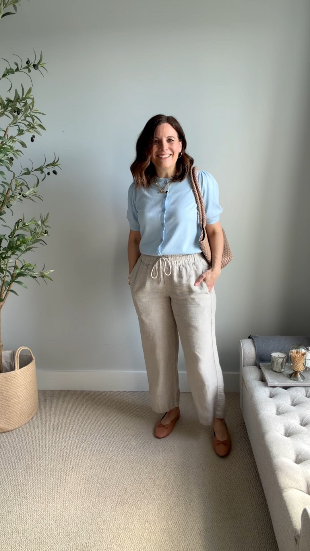 Here I’m wearing a short-sleeve cardigan buttoned up as a top for a work look.
I tried it untucked, but it felt a little long, so I prefer it tucked in. Nude ballet flats and a matching tote finish the look and keep everything cohesive. These khaki linen pants fit true to size. I’m in a medium in the 28 inch inseam. ￼

#LTKOver40 #LTKMidsize #LTKSaleAlert
