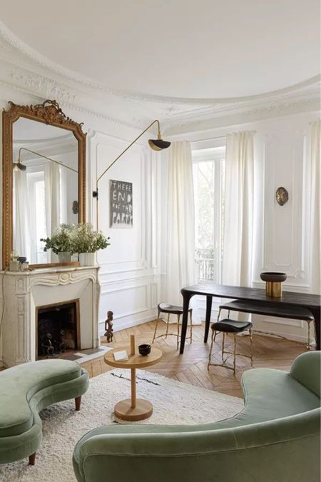 Parisian living room

White linen curtains, gold mantle mirror, MCM long arm black wall sconce, black rectangular dining table, dining bench, Moroccan rug, round side table, curved green velvet sofa 

#LTKstyletip #LTKhome #LTKFind
