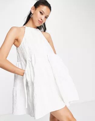 ASOS DESIGN jacquard halter neck swing tiered mini dress with bellow pockets in white | ASOS (Global)