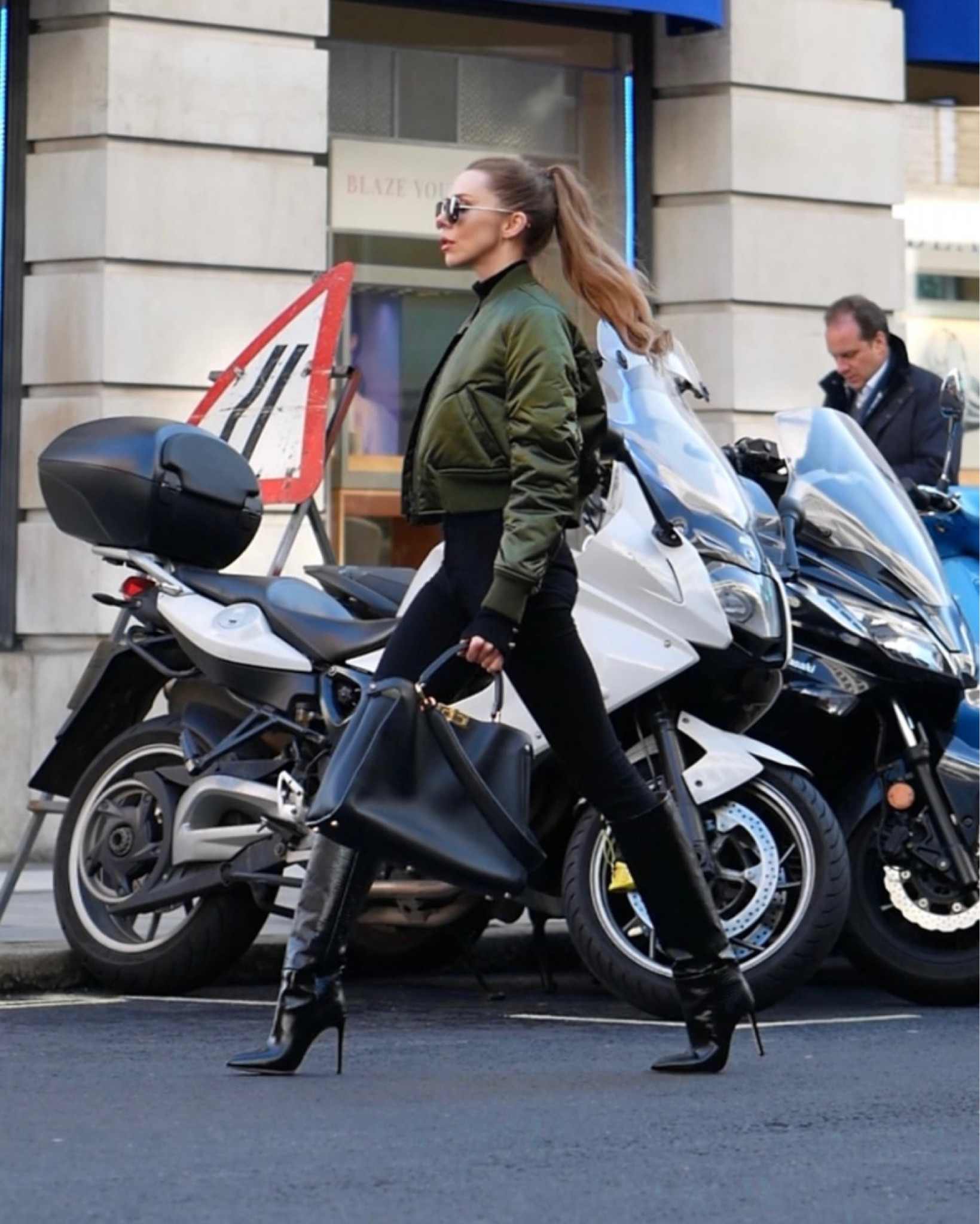 Green bomber jacket and black knee high boots