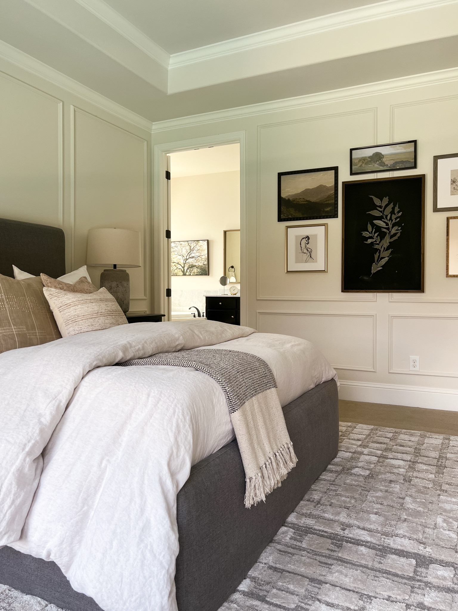 Neutral master bedroom decor with gallery wall art, linen bedding, and neutral textured rug



#LTKHome