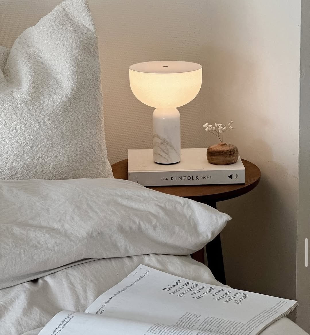 Simple pleasures in a cozy corner. ☁️  This little bedside setup is my current happy place.  Soft linen sheets, a good book ("The Kinfolk Home" always inspires!), and the gentle glow of this amazing lamp. I love the marble base of the lamp; it's a touch of luxury without being fussy.  And how cute is that tiny vase with dried flowers? Sometimes the simplest things bring the most peace. Wishing you all a relaxing evening! What are your go-to bedtime rituals?

#CozyVibes #BedroomDecor #BedsideTable #HomeDecor #InteriorDesign #Minimalist #KinfolkHome #Relaxation

#LTKActive #LTKHome #LTKSeasonal