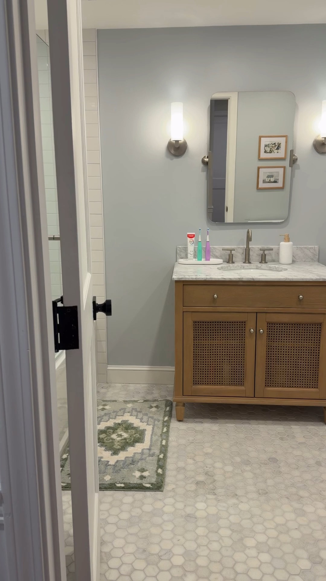 This bathroom may belong to our boys, but it’s one of the prettiest rooms in our home. The mix of blue, white, and natural wood tones keeps it feeling fresh, classic, and not overly themed - while still being kid-friendly and functional for everyday life. I’ve rounded up all the details below.

Shampoo niche tile is THASSOS BLUE CELESTE BASKETWEAVE POLISHED MARBLE MOSAIC from floor & decor. Floor is honed marble hexagon and bath alcove is an elongated subway tile.

#LTKHome #LTKKids