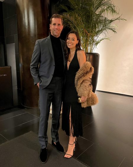 Kat Jamieson wears a black fringe dress, strappy black heels, a Chanel necklace, and a vintage fur coat with her husband who wears a suit and velvet loafers to dinner. Date night, cocktail party, formal, dressy. 

#LTKwedding #LTKmens #LTKshoecrush