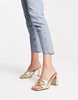 ASOS DESIGN Hush snaffle detail mid heeled mules in gold | ASOS (Global)