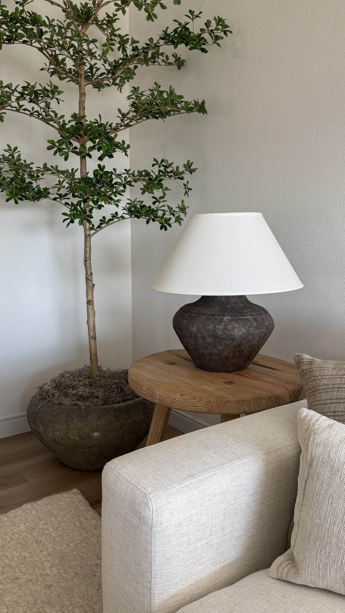 Neutral home decor ideas with an organic modern touch. Featuring a textured ceramic lamp, round wood side table, and faux olive tree for a cozy earthy living room aesthetic. Shop my favorite modern organic home finds to bring warmth and natural textures into your space. 

 #LTKHome