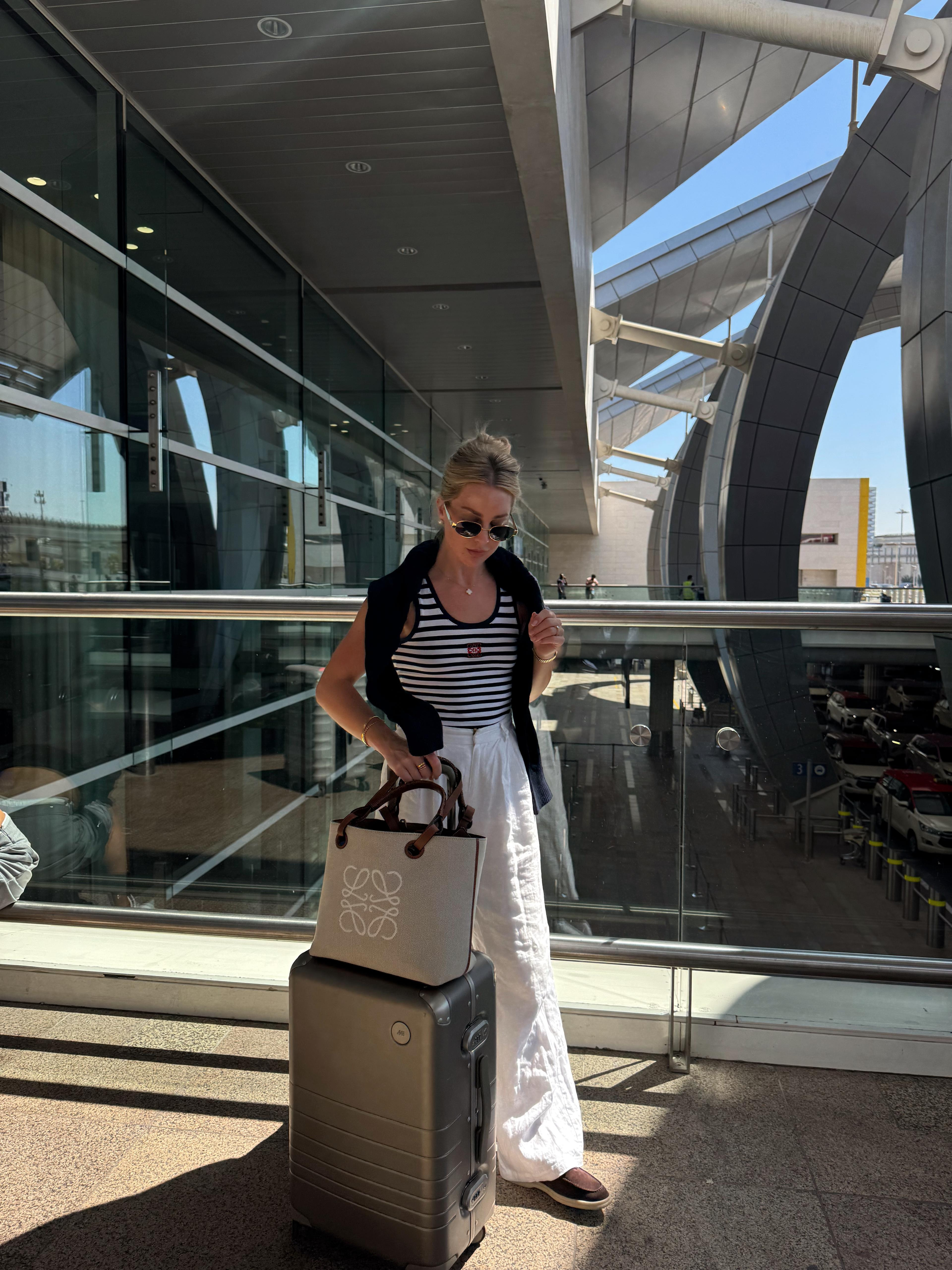Airport outfit, striped Loewe tank top, Dissh white linen trousers, brown loafers, Ralph Lauren cardigan, casual style, winter sun, travelling outfit, plane airport, Loewe bag, casual style 

 #LTKuk #LTKspring #LTKstyletip