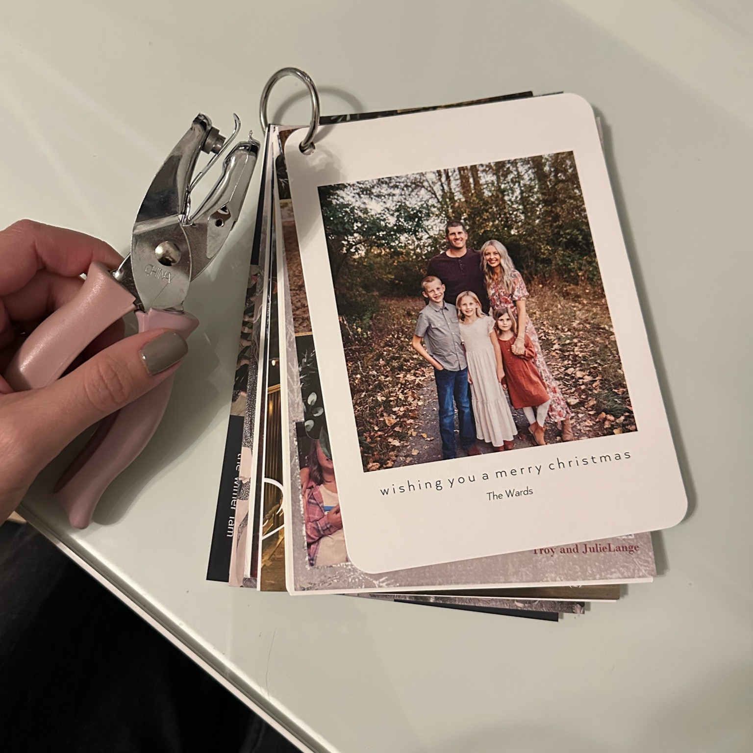 Easy way to organize and save your Christmas cards each year! Use a hole punch to add a hole into a corner of each card, and then slip a metal o-ring through to clip them all together.

#LTKHoliday #LTKfindsunder50 #LTKfamily