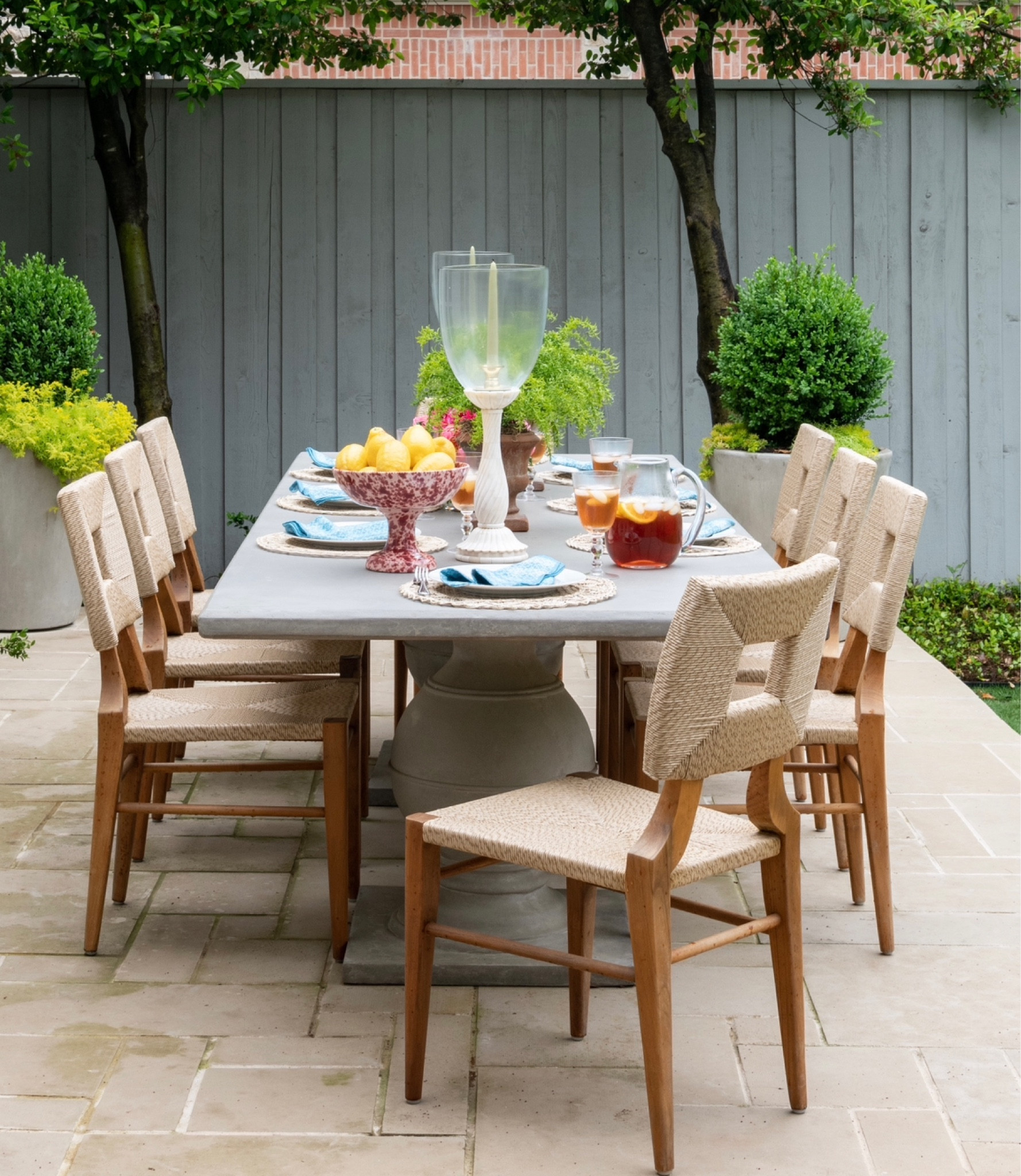 Summer table scape layered with pretty hand painted pieces, hurricanes for height and a touch of rattan! 