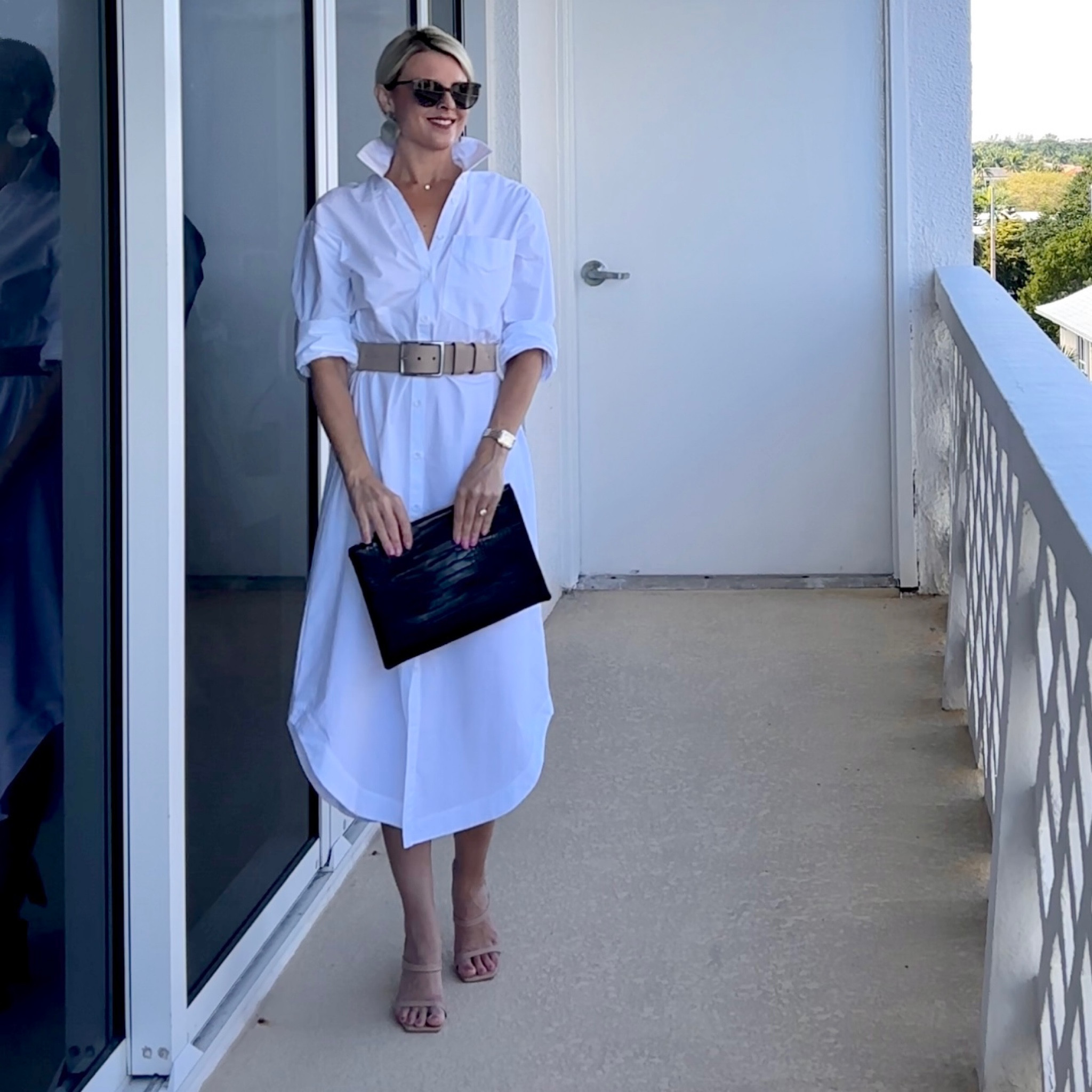 Styling a long button down shirt dress with flat circular earrings and sleek details. 

#LTKFind