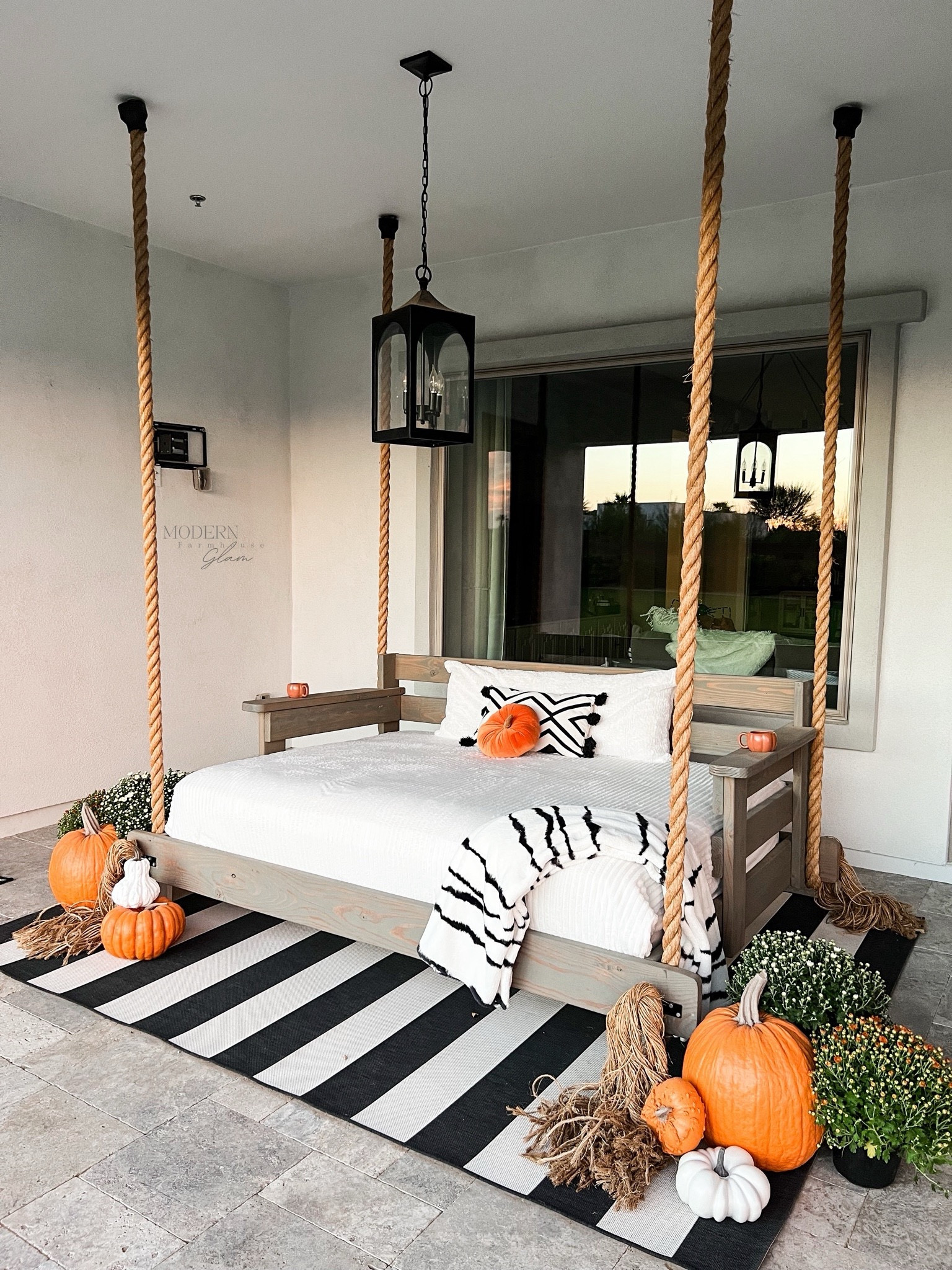 DIY porch bed swing made by Modern Farmhouse Glam. Black and white striped outdoor rug. Fall pumpkin decor  

#LTKHome