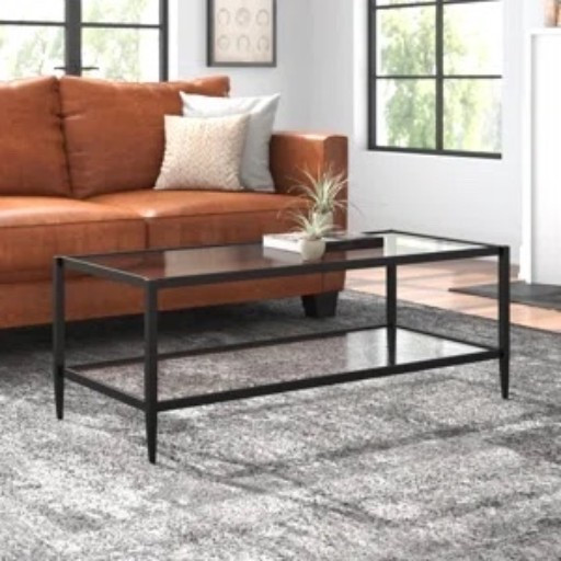 This black glass-top coffee table from Wayfair is such an easy piece to build a living room around. The slim metal frame keeps it feeling light, while the rectangular glass top gives you plenty of room for books, a little plant, or whatever ends up living on the coffee table day to day. I really like it with the cognac leather sofa, neutral throw pillows, and soft gray area rug.