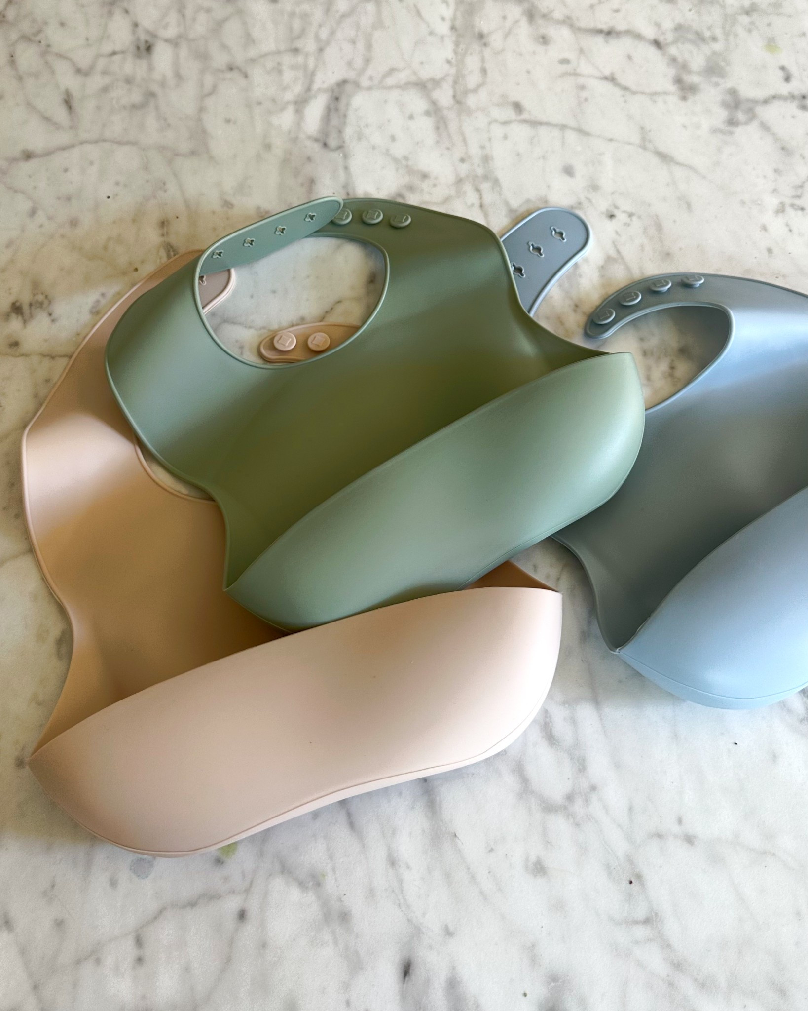 Silicone Bibs! 
The are very flexible and thin and lay flat on my son and the thick straps and interlock clasp make them so secure! LOVE 💕 