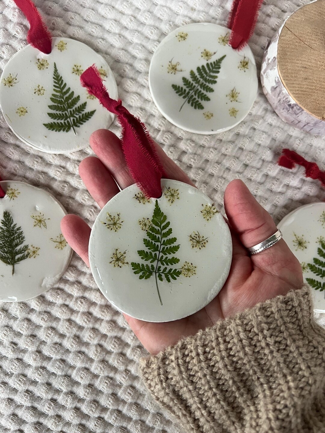 Bring a touch of the outdoors to your holiday décor with this handcrafted pressed flower ornament. Each piece is shaped from oven-baked clay, accented with real farm-grown grasses, and finished with a smooth resin coat that adds shine and durability. With every design uniquely made and paired with a soft cotton hanging loop, it’s a meaningful gift for gardeners, nature lovers, and anyone who appreciates organic beauty. #EtsyFinds #LTKHoliday #PressedFlowerArt #NatureInspiredDecor #ChristmasOrnament #GardenLoversGift

#LTKGiftGuide #LTKSeasonal #LTKHoliday
