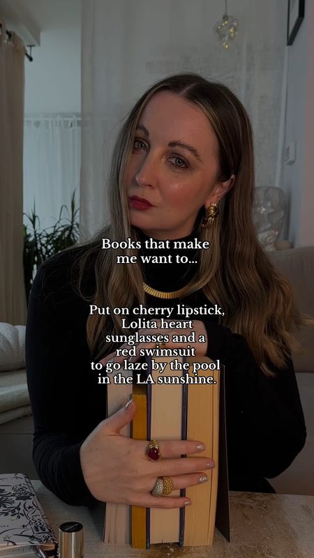 Books that make me want to…
Put on cherry lipstick, Lolita heart sunglasses and a red swimsuit to go laze by the pool in the LA sunshine. ♥️💋🌊
Black polo neck | Writers outfits | Red lipstick | Clarins lip oil | Gold jewellery | holiday reads

#LTKhome #LTKeurope #LTKbeauty