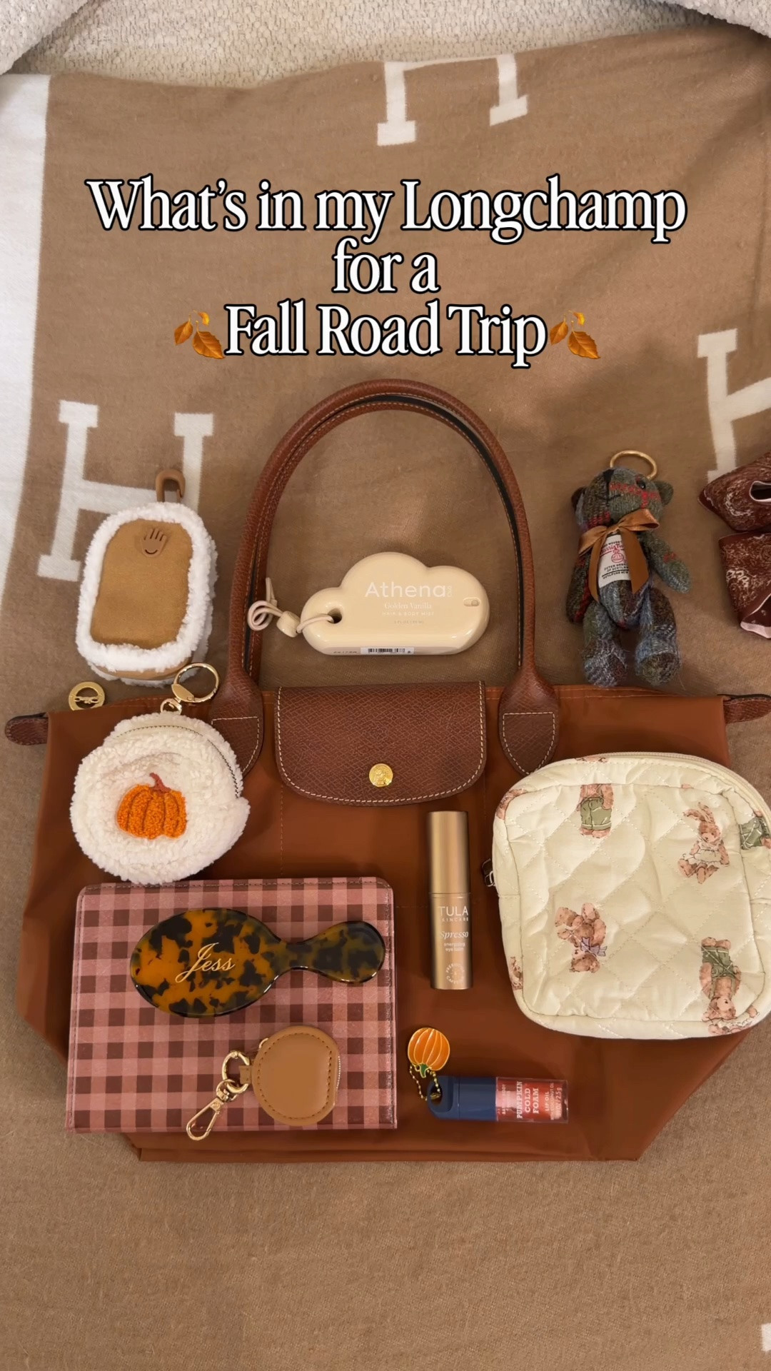 What’s in my Longchamp Le Pliage 🍂Fall Road Trip Edition🍂 Comment SHOP & I’ll dm you the links ♥️

What’s in my bag:
Medium Longchamp Le Pliage in cognac
Felt bag insert
Plaid kindle case form Amazon
Planner 
Teddy bear pouch
Clear kisslock pouch
Custom hairbrush from Etsy
YSL mini blush
Mini real techniques sponge
Rare beauty travel blush
Tula spresso brightening eye balm
Athena vanilla spray charm
Touchland suede and shearling case
Touchland pumpkin hand sanitizer
Mini jewelry pouch
Bath and body works pumpkin cold foam lip gloss
Harris tweed bear charm
Pumpkin pouch