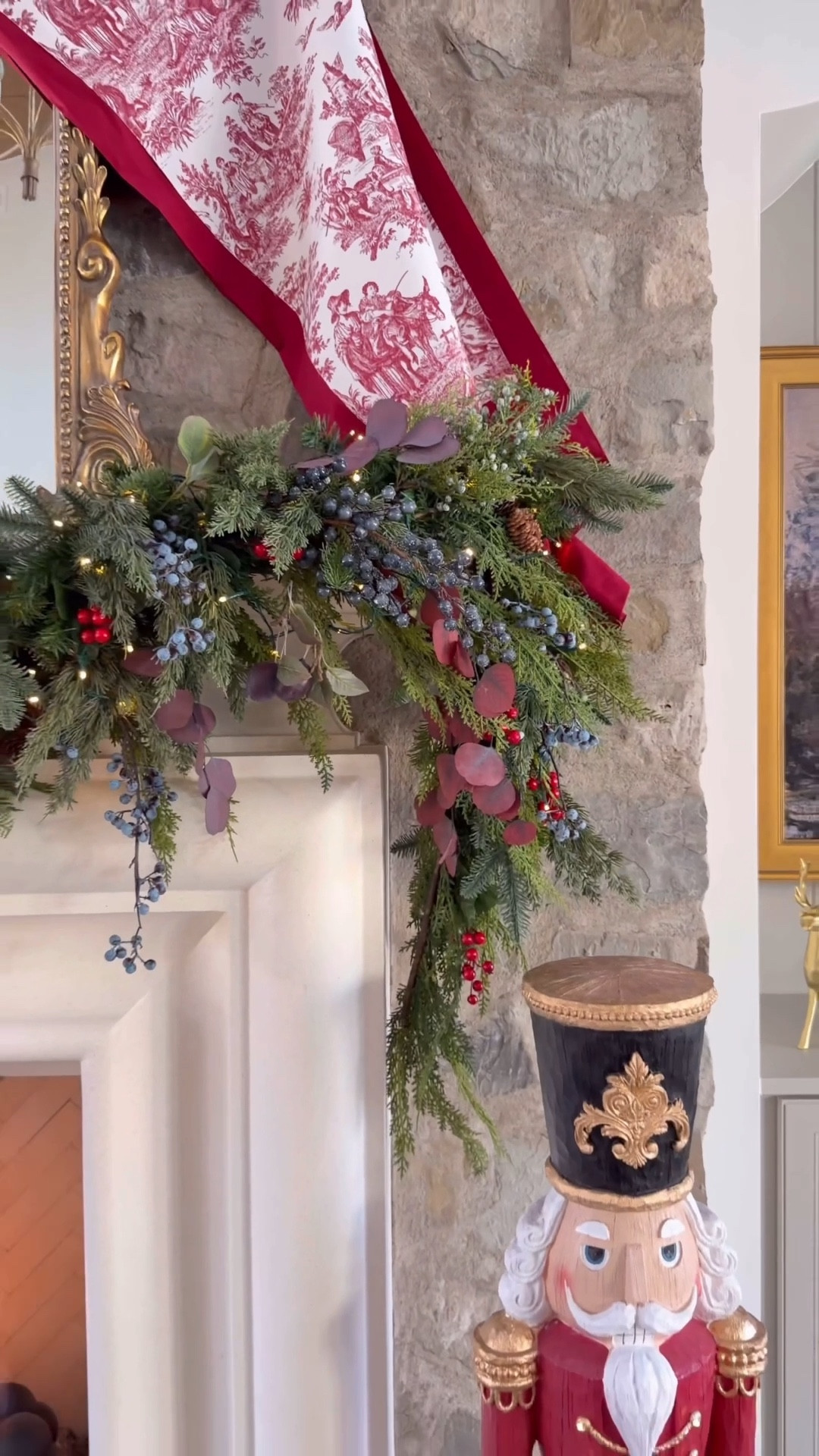 Traditional Christmas mantel with mixed berry stems and a giant toile bow. 
Blueberry stems 
Red berry stems
Faux cedar garland
Mixed green garland
Hanging straps 
Fireplace cannons 
Giant nutcrackers red velvet ribbon 

#LTKHoliday #LTKSaleAlert #LTKHome