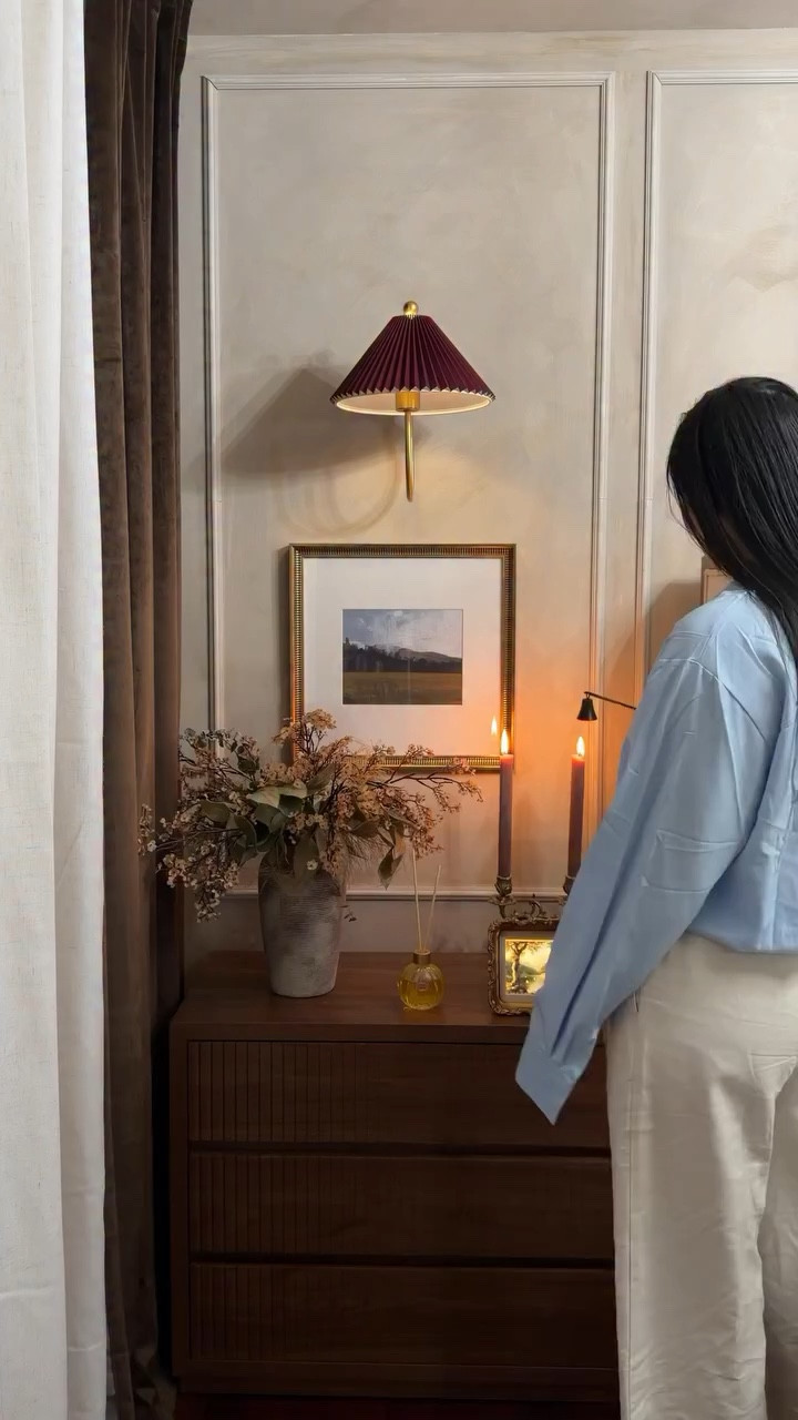 🇺🇸
one of my favorite little corners in my bedroom is finally starting to take shape…

this is the left side where I keep a simple vase with greenery, my favorite scent at the moment (the @tocca Cleopatra diffuser), and pieces that make the space feel a little more like me.

on the other side, where my Alexa sits, I customized it with a gold frame to give it a more classic, almost vintage feel like it actually belongs in the room instead of standing out.

and of course… a vintage candelabra I found in Romania, with taper candles that instantly bring that soft, warm glow I love at night.

the artwork, the aged gold frames, the burgundy tones… everything is slowly coming together in a way that feels calm, intentional, and a little bit like a hotel I never want to leave.

it’s really true the smallest details end up making the biggest difference.

⸻

🇧🇷
finalmente um dos meus cantinhos favoritos aqui do meu quarto está começando a tomar forma…

esse é o lado esquerdo — onde eu deixo um vaso com planta, o meu cheirinho favorito do momento (o difusor Cleopatra da TOCCA) e alguns detalhes que fazem o espaço parecer mais com a minha cara.

do outro lado, onde fica a minha Alexa, eu customizei ela com uma moldura dourada pra trazer esse ar mais clássico, quase vintage — como se ela fizesse parte da decoração e não ficasse “sobrando” ali.

e claro… um candelabro vintage que eu comprei na Romênia, com velas que trazem aquela luz mais suave e aconchegante que eu amo à noite.

os quadros, as molduras em ouro envelhecido, os tons de burgundy… tudo está se encaixando aos poucos de um jeito mais calmo, intencional, e com aquela vibe de hotel que a gente nunca quer ir embora.

no fim, são sempre os pequenos detalhes que fazem todaa diferença.

#bedroomdecor #bedroomdecoration #homedecorinspo #vintagedecor