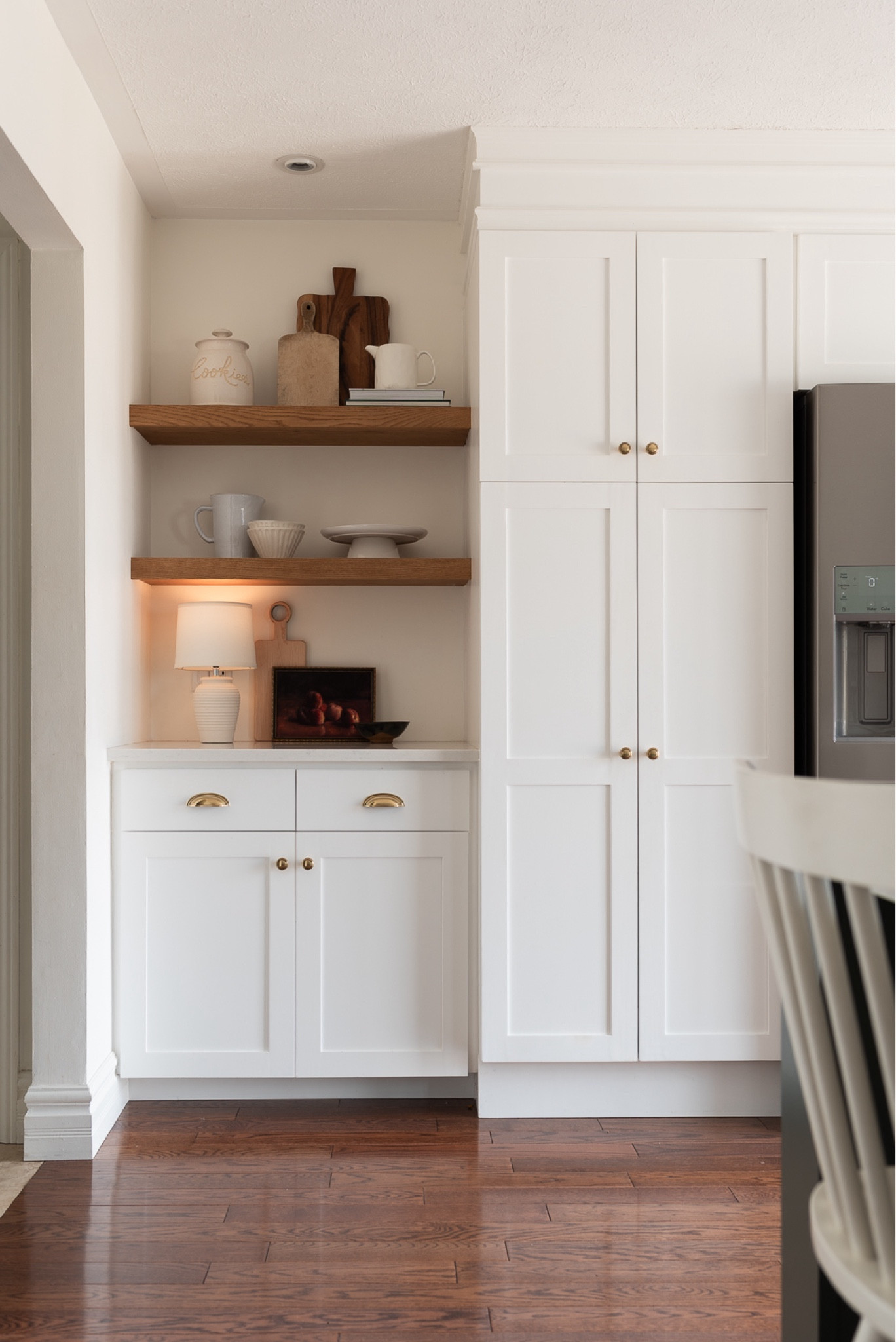 A miniature lamp adds warmth to a kitchen. 

Vintage cutting boards, pottery, ceramic pitchers, cake plates, vintage art, vintage still life art, cook books, open shelving, kitchen shelves, brass hardware 


#LTKhome