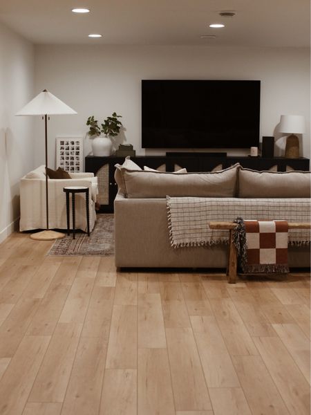 Basement family room
Living room
Sectional
Floor lamp
Wood bench
Checkered throw

#LTKstyletip #LTKhome