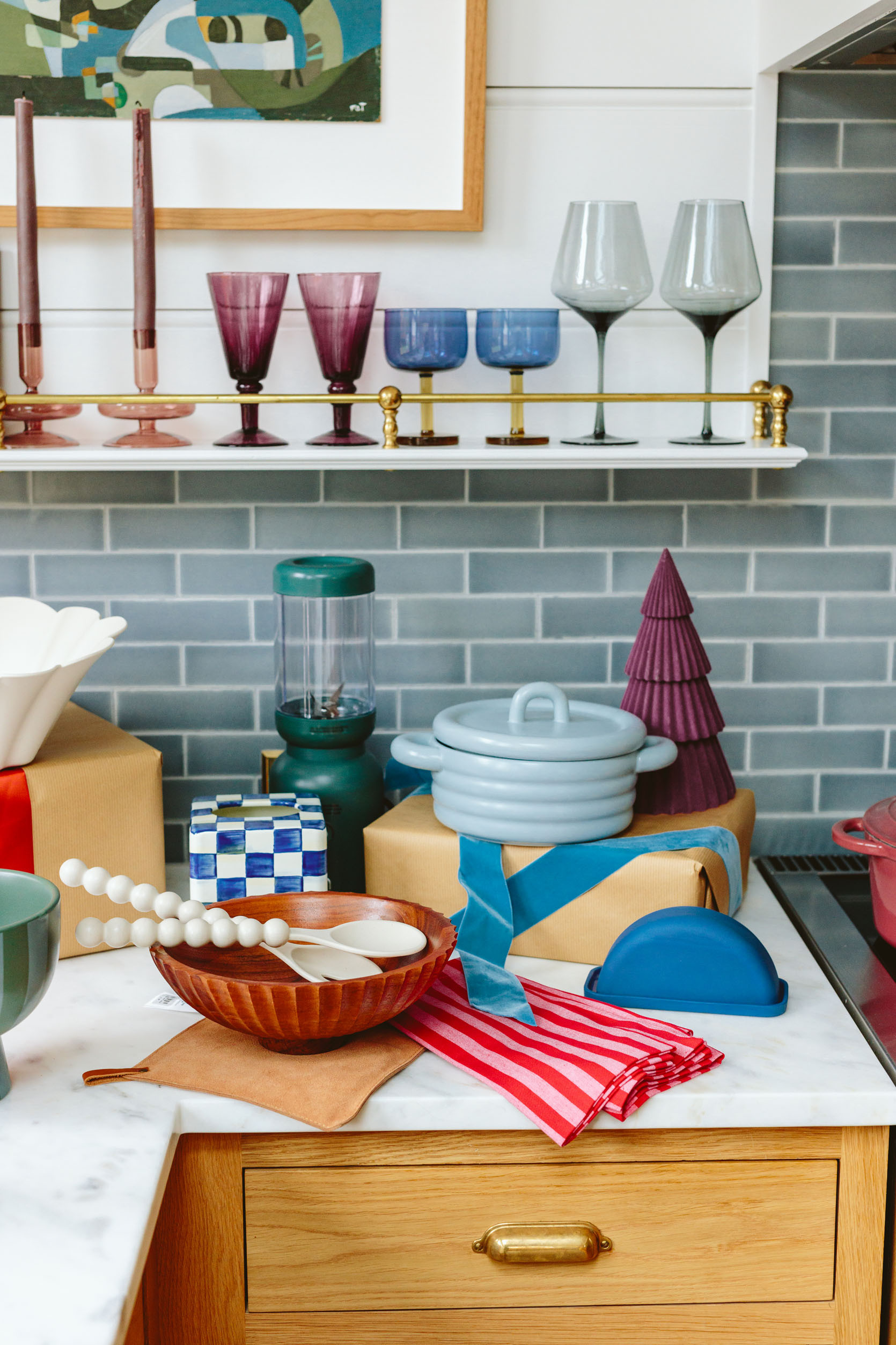 In here I found some pretty awesome stuff for the kitchen that I couldn’t believe how cute and affordable it was – the light blue covered baking dish? SO CUTE (great for sides but also comes bigger in white). The footed blue/green vessel(under $20) and the scallop candle holder (could be year-round on the dining table with nonholiday candles) – both are styling staples. As you can see all of these pieces have something really special about them – either the shape, the texture (the scallop, the round ribbing), or the perfect color.

The red stripe napkins are $3 each and while of course, they are excellent Christmas napkins, red is having such a moment that I’d use it in spring and summer, too. They feel really high quality. The glassware that I collected on the shelves are just better than basic – the two-toned glasses are thick and special (and splurgier) while the purple goblets are affordable and so rich. And don’t forget the $8 glass candle holders – so good, so pretty, so affordable. I have them on my coffee table.

The green blender is countertop worthy (I just bought it for myself and love it), and while that tissue box cover is on the splurgy side it also comes in black and white and it’s metal. Let’s just say it brings me more joy than I originally predicted (I also love the tray version of it and have it on my coffee table).

#LTKGiftGuide #LTKHoliday #LTKHome