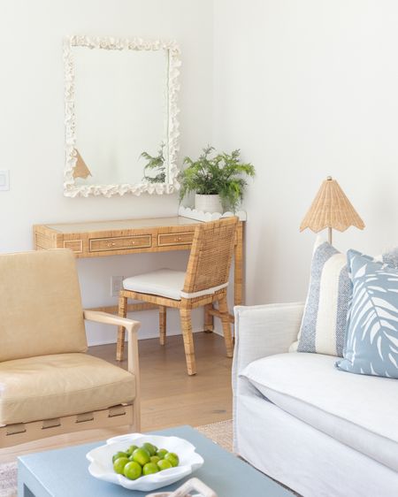 Our Florida carriage house living room features a slipcovered indoor/outdoor sofa, camel leather chairs, block print rug, a light blue coffee table, scalloped rattan lamps, round side tables, oversized palm art, and light blue tropical pillows! I love our white coral mirror hanging over this affordable rattan desk, too! Take the full tour here: https://lifeonvirginiastreet.com/our-florida-carriage-house-tour/.
.
#ltkhome #ltkseasonal #ltksalealert #ltkfindsunder50 #ltkfindsunder100 #ltkstyletip #ltktravel #ltkover40 coastal living room decor, Serena & Lily style, coastal grandmillennial, coastal grandmother aesthetic 

#LTKhome #LTKsalealert #LTKSeasonal