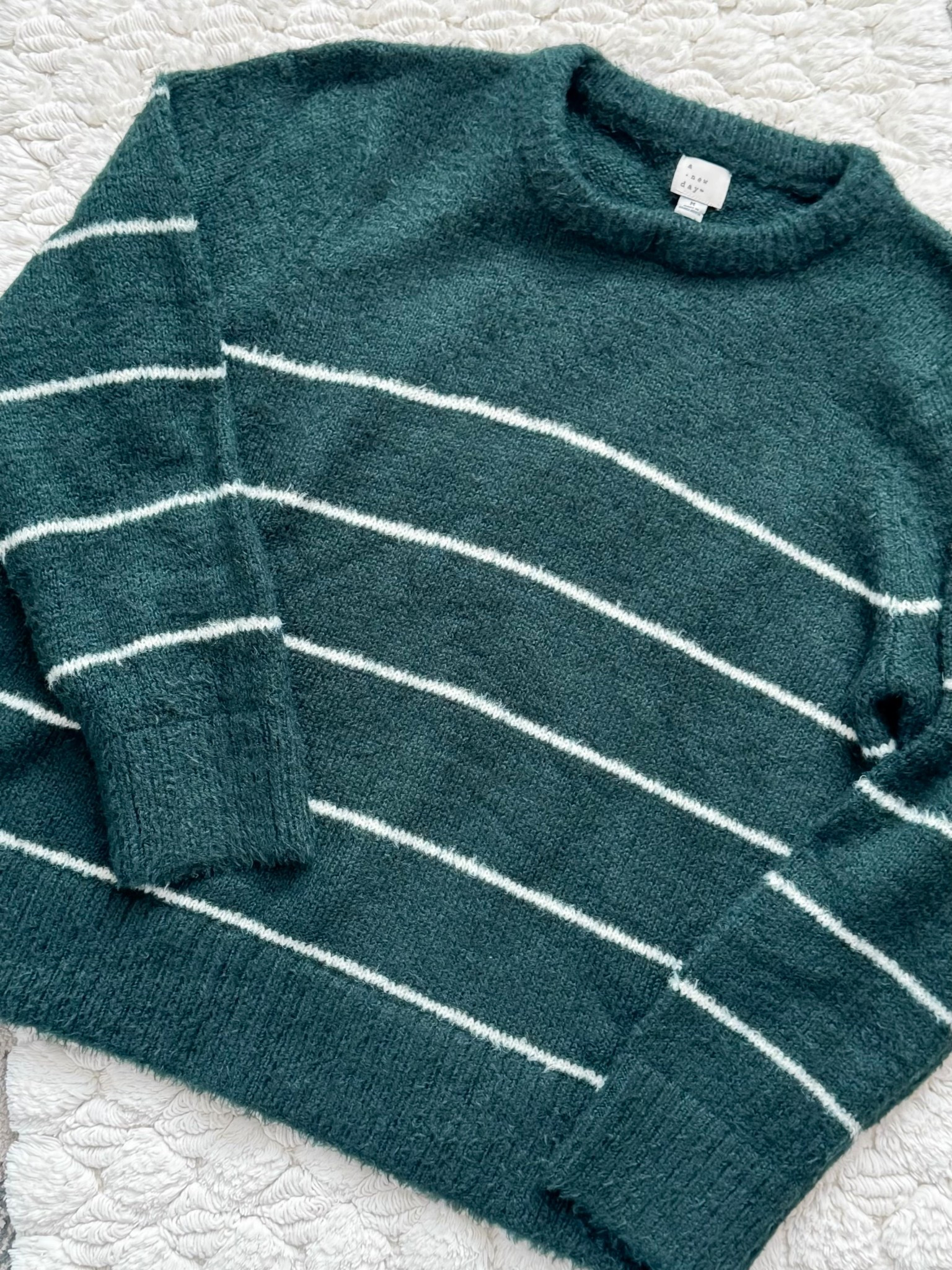 This ultra-soft, brushed knit sweater is the definition of cozy-chic. The deep evergreen paired with delicate ivory stripes gives it that elevated, winter-ready look that feels perfectly festive without being over the top. Designed with a relaxed, slightly cropped fit, chunky ribbed hem, and a comfy mock neckline, it layers beautifully for chilly days and keeps its shape wear after wear. The plush, fuzzy texture makes it feel extra luxe — the kind of sweater you’ll reach for all season long, whether you’re headed to a holiday party, a family gathering, or just curling up with cocoa by the fire. It’s timeless, flattering, and gift-able for literally everyone on your list.
Comes in 4 color options.
I got a size Medium for a little extra length + bigger chest. 

How to style it:
• Pair with dark-wash skinny jeans or straight-leg denim + ankle boots for an effortless holiday look.
• Tuck into a satin midi skirt + heels for a dressy gathering vibe.
• Wear with faux leather leggings + sneakers or suede clogs for casual weekends.
• Layer over a white collared shirt with trousers for a polished, classic outfit.
• Finish with gold hoops, a sleek claw clip, and a neutral crossbody bag.

Perfect for: holiday parties, Christmas photos, family dinners, office parties, winter travel, cozy weekends, gift exchanges, and everyday winter outfits.

cozy sweater • holiday outfit ideas • winter style • striped sweater • neutral style • fall and winter fashion • gift ideas for her • ltkstyle • wardrobe essentials • affordable fashion • minimal style • cozy chic • winter wardrobe • sweater weather • trending now • holiday fashion • women owned style • classic style • modern fashion • simple outfits • capsule wardrobe • soft knit • everyday style

#LTKootd #LTKGiftGuide #LTKOver40