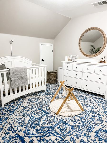Simple baby boy nursery with blues whites and greys. 
.
White target crib, blue square rug, beautiful play gym, round hanging mirror, grey baby quilt, hatch changing pad, diaper caddy, jelly cat stuffed bunny. 

#LTKhome #LTKbaby #LTKbump