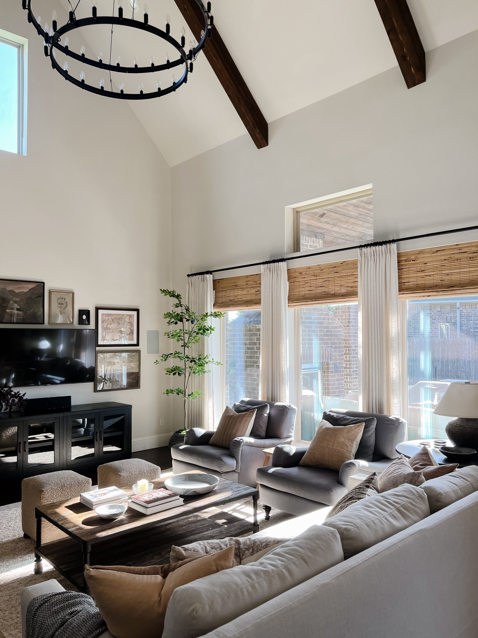 Neutral living room with grey chairs, white sofa, bamboo blinds, ivory drapes, and black media console



#LTKHome