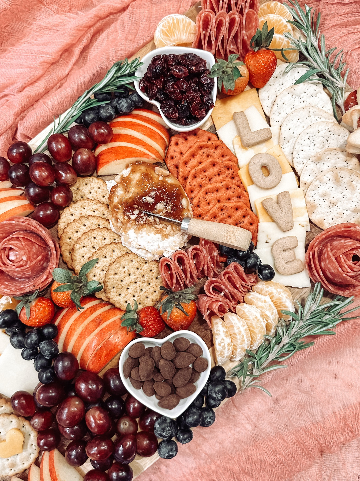 Sharing everything I used for my Valentines charcuterie for some inspiration! A few tips… balance your board with the same food on each side, use both sweet and salty options, use smaller food for filler like blueberries, nuts, and rosemary. I love using cutouts and letters, and I always recommend sweet treats or cookies also around the edges or on top! 🎀🧀🍇🍾
