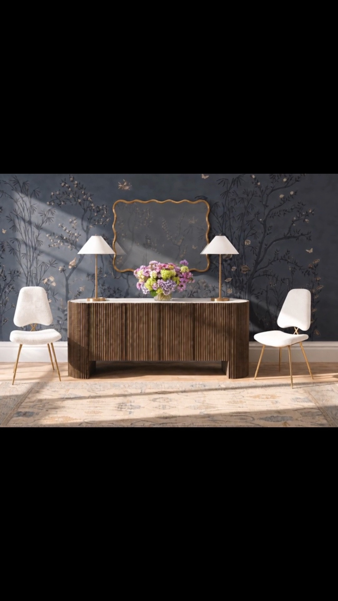This look could work beautifully in an entryway, dining room, or living room—anywhere you want to create a polished moment with real presence.

I especially love the hand-painted chinoiserie mural. Its deep blue botanical scene gives the room so much character, while the fluted sideboard, sculptural mirror, brass lamps, white bouclé dining chairs, and soft patterned runner keep everything feeling refined and balanced. The vibrant flower arrangement adds just the right amount of life and color.

#Entryway #LivingRoom #DiningRoom #Sideboard #ConsoleTable #ChinoiserieMural #HandPaintedMural #Mural #DiningChair #BoucleChair #RunnerRug #FlowerArrangement #FloralDecor #TableLamp #WallMirror #ModernClassic #LTKHome #LTKdayinmylife #LTKSaleAlert

#LTKHome #LTKdayinmylife #LTKHome #LTKSaleAlert