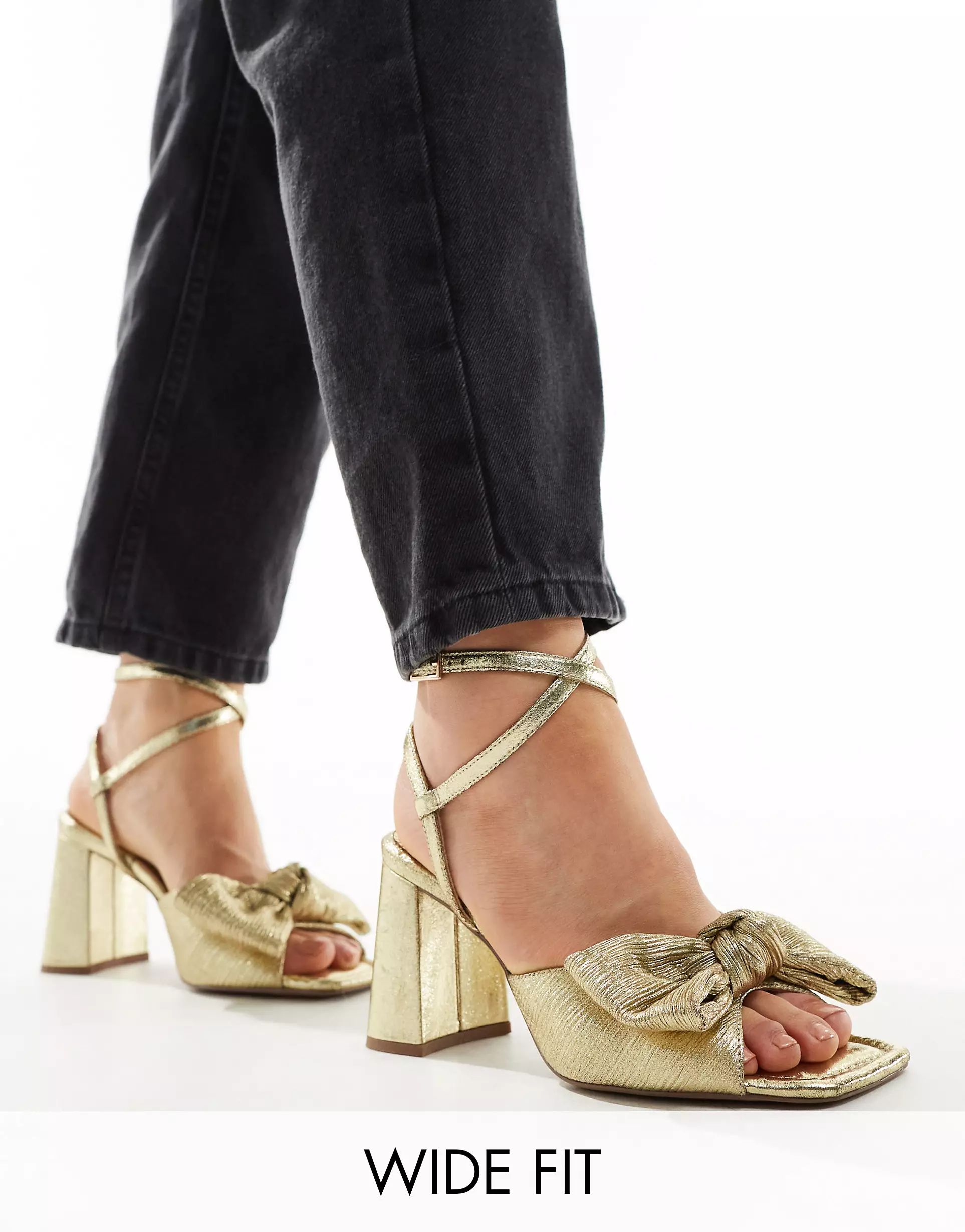 ASOS DESIGN Wide Fit Hitched bow detail mid block heeled sandals in gold | ASOS (Global)
