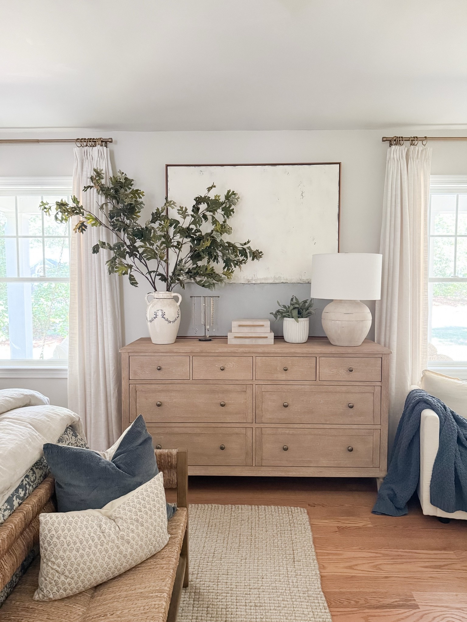 Light wood dresser styled with oversized neutral artwork, ceramic table lamp, stacked decorative boxes, and greenery in a white vase. Balanced, minimal coastal styling for a serene bedroom. 
dresser decor, bedroom dresser styling, oversized wall art, neutral artwork, decorative boxes, ceramic lamp, greenery vase, coastal bedroom decor, light wood furniture, minimalist home decor, organic modern bedroom, styled surfaces, sherri calnan home

#LTKHome