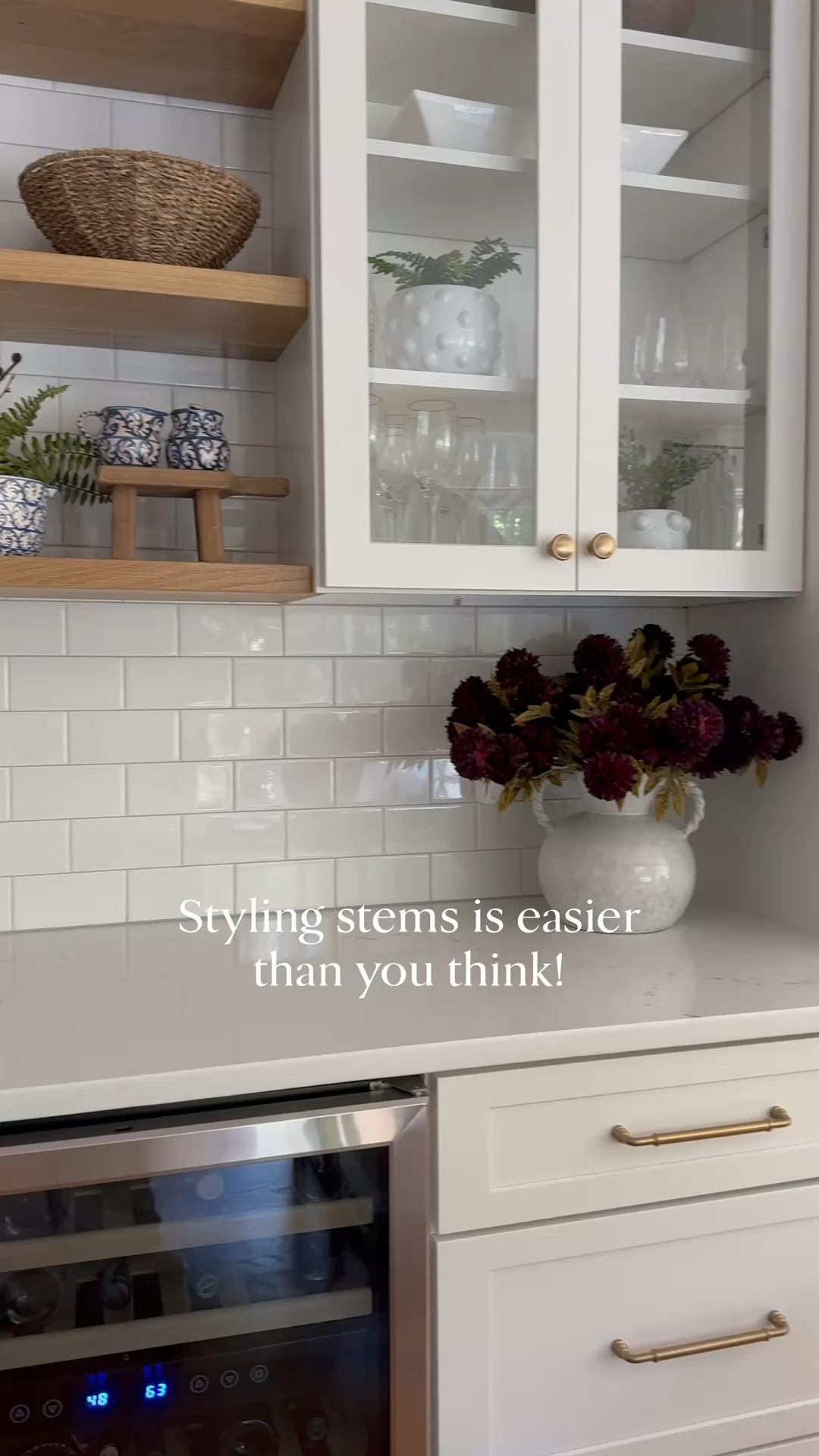 How to style stems in a pretty vase. This cape cod coastal kitchen keeps everything light, layered, and beautifully organized. Cape cod kitchen, coastal kitchen cabinets, glass cabinet styling, neutral kitchen decor, open shelf kitchen styling, amazon finds home decor, coastal neutral kitchen, sherri calnan home

#LTKHome