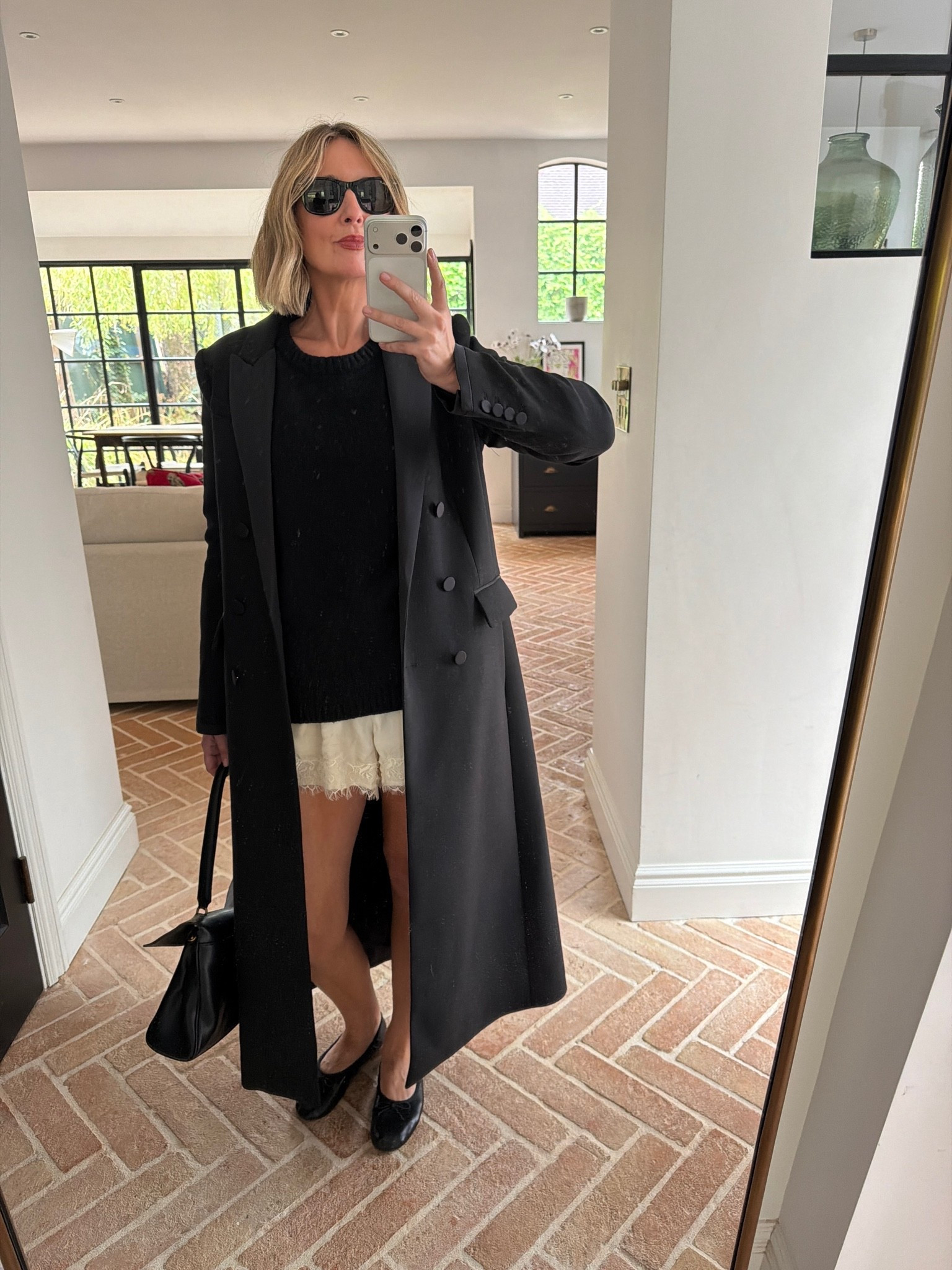 black tailored maxi coat, double breasted trench coat, black knit sweater, ivory lace hem shorts, black bow ballet flats, black slouchy shoulder bag, black sunglasses, layering knitwear over shorts, transitional dressing, autumn outfit, quiet luxury, elevated basics, effortless chic, ltkstyletip, ltkseasonal, ltkfindsunder100, outfit inspo, capsule wardrobe essentials

#LTKFashionMonth #LTKeurope #LTKpartywear