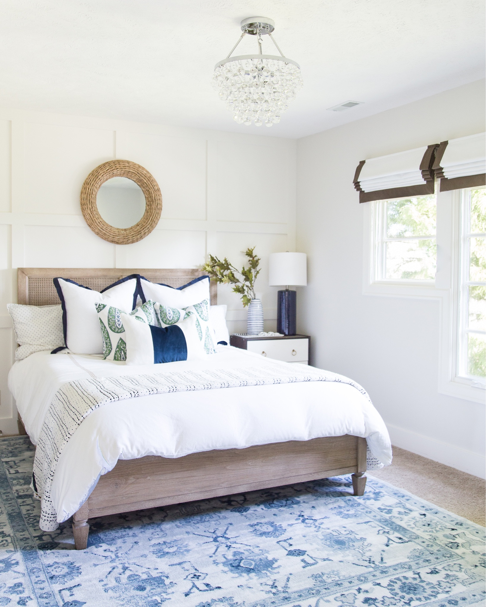 Cozy coastal vibes in our guest bedroom.  Neutral decor items include a natural wood and cane bed, a round rope wall mirror, a crystal chandelier, a vintage blue and white area rug, an Ikea hack nightstand, a blue ceramic table lamp, a floral reversible quilt, several decorative pillows and brown and white roman shades.

simple decor, bedroom decor, bedroom lighting, bedroom mirror, guest bedroom inspiration, area rug, target chair, amazon home decor, master bedroom decor, pottery barn bed, pottery barn inspired room, coastal bedroom, bedroom bedding,  classic design, simple decorating, target style, bedroom rugs, guest bedroom décor, target home décor, amazon finds, serena and lily bedding, bedroom area rug, master bedroom, guest bedroom, bedroom decorating #ltkfamily 

#LTKSeasonal #LTKstyletip #LTKunder50 #LTKunder100 #LTKhome #LTKsalealert #LTKhome #LTKfamily #LTKstyletip