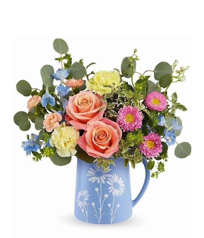 Gift mom a radiant bouquet of flowers this Mother’s Day. This charming blend of peach roses, yellow carnations, peach mini carnations, and light blue delphinium creates a soft, cheerful look. Arranged in a keepsake pitcher vase, this bouquet is perfect for celebrating any special moment. Available in three sizes - regular (as shown), deluxe, and premium. ON SALE and under $60.

Includes:
• Peach Roses
• Yellow Carnations
• Peach Mini Carnations
• Light Blue Delphinium
• Floral Greenery
• Keepsake Blue Daisy Pitcher
• Personalized Card Message

#LTKMothersDay #LTKHome #LTKSaleAlert