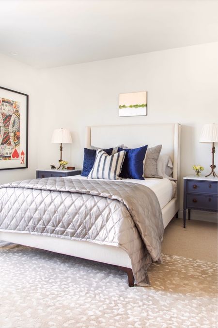 The handsome primary bedroom design for my Niles Place project, featuring a shelter bed frame, blue French nightstands, brass table lamps, gray bedding, spotted antelope area rug, playing card collage artwork, blue decor

#LTKFind #LTKstyletip #LTKhome