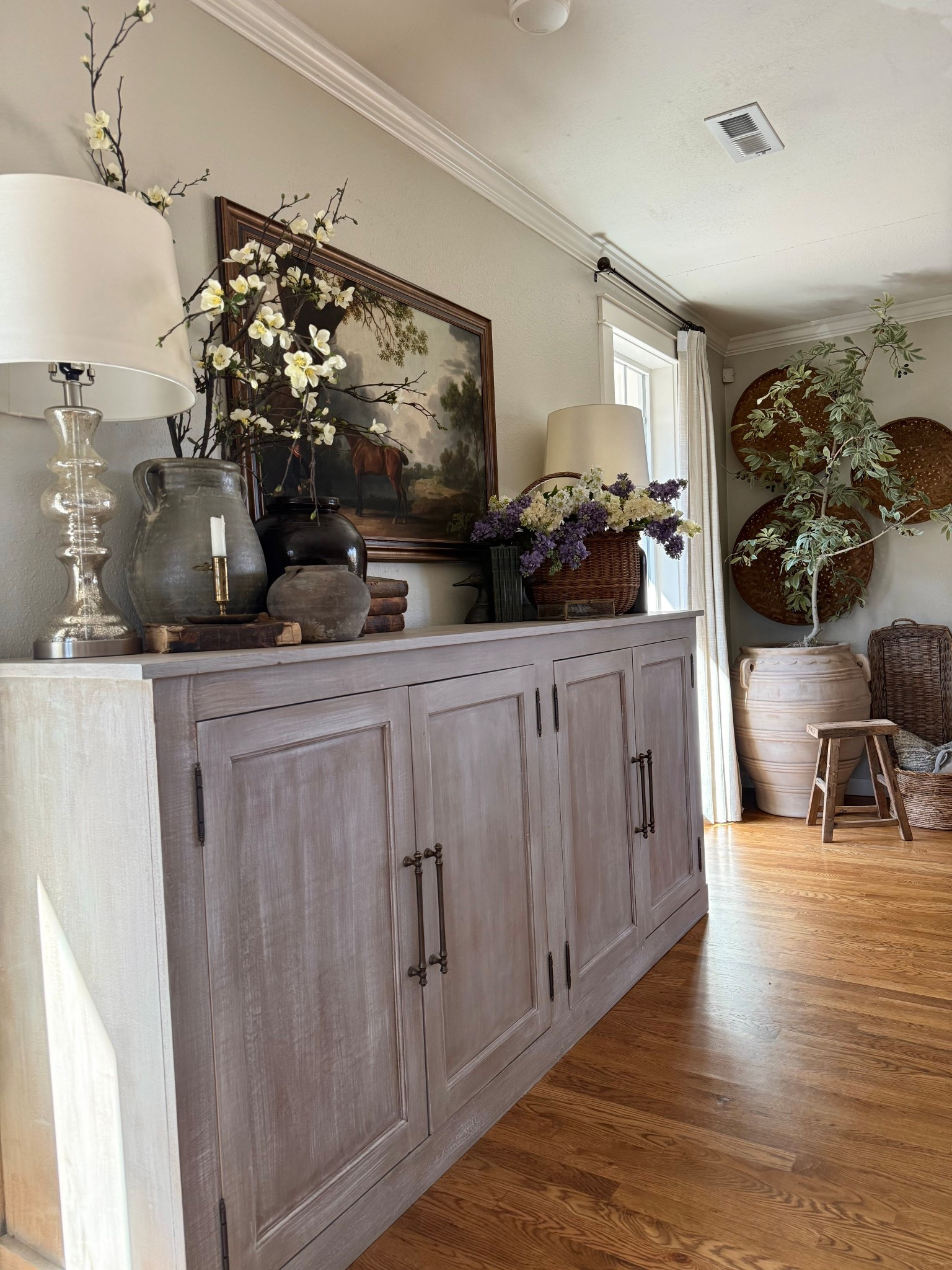 🌿 The sideboard that feels like it was collected across a lifetime of European travels.
Vintage equestrian prints. Antiques mixed with beautifully sourced finds. Crocks, pottery, and storied little touches that feel like they came from a Paris flea market or a Provence farmhouse. 🏇🤍
And then — the lilacs. A French basket overflowing with the most realistic stems, sprayed with actual lilac fragrance. The moment you walk in the room, you know. 🌸
Layered. Lived in. Completely collected. This is the vignette that makes your home feel like a story. ✨


#LTKSpringSale #LTKHome #LTKSeasonal