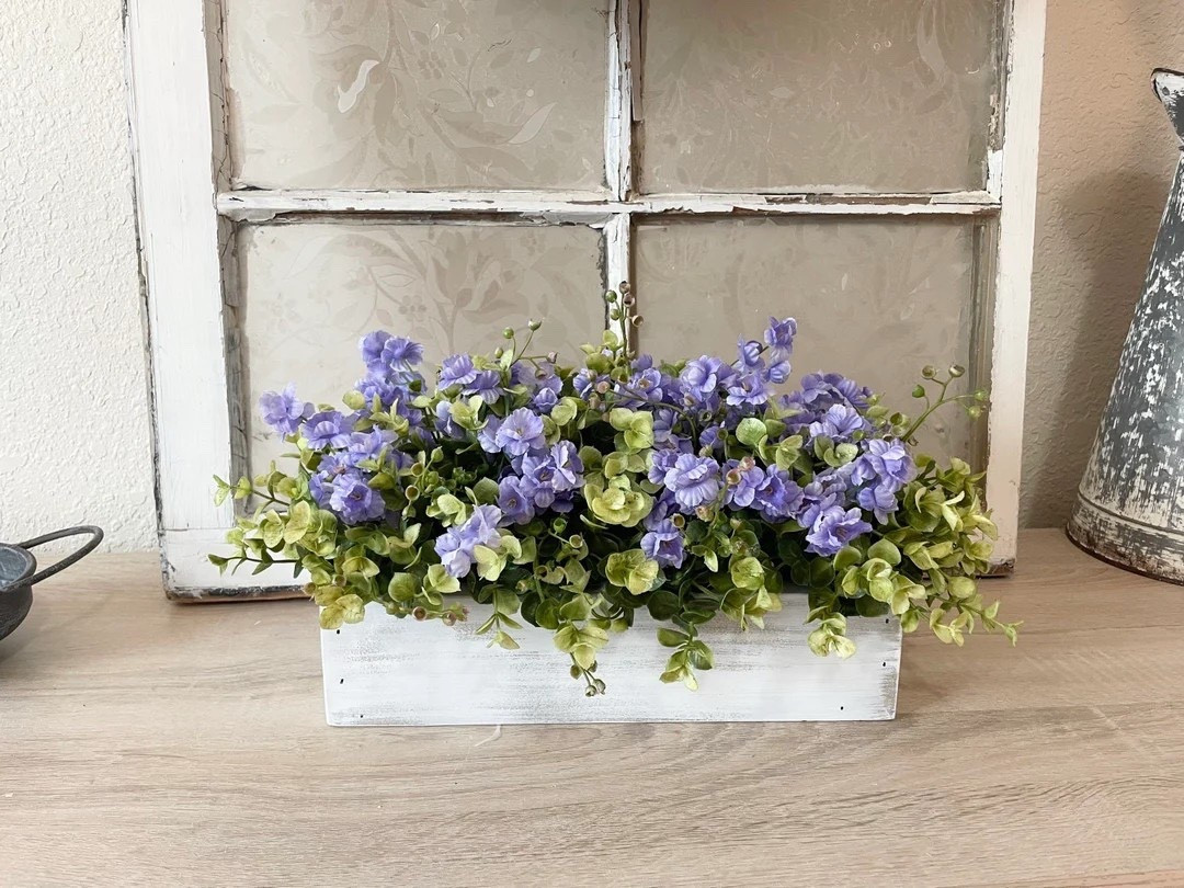 Add a soft, romantic touch to your home with this farmhouse-inspired floral centerpiece by CountryHomeandHeart. Designed in a handcrafted pine wood box and filled with lush greenery and ruffle-style blooms, this piece can be fully customized to match your space. With multiple sizes, finishes, and flower colors to choose from, it’s the perfect way to create a personalized statement for your table, mantel, or entryway. #LTKHome #FarmhouseDecor #TableCenterpiece #FloralDecor #HomeStyling #RusticCharm #NeutralHome #CozySpaces

#LTKSeasonal #LTKHome #LTKWedding