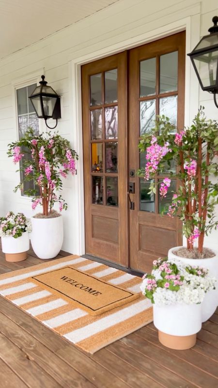 Spring Front Porch!! Loving these wisteria trees! Use BRUNOANDLIBBY for 30% off at nearly natural! Jute rug is 4x6. Front porch and front door decor large white planter trending viral home decor pottery barn dupe look a like look for less artificial faux plants trees flowers florals greenery modern farmhouse southern porch lantern, outdoor light fixtures, wall sconces lighting silk faux flowers d geraniums, hydrangeas kalanchoes pink florals jute rug scatter rug welcome mat doormat, double layered

#LTKSeasonal #LTKhome #LTKstyletip