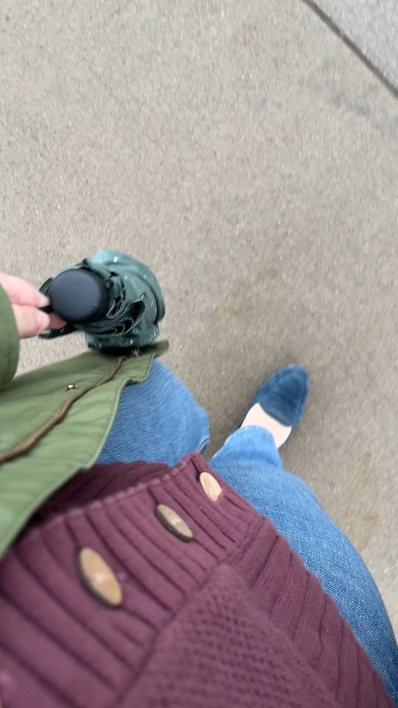 Rainy day outfit headed to the office - green rain jacket, polka dot umbrella, cozy purple cardigan