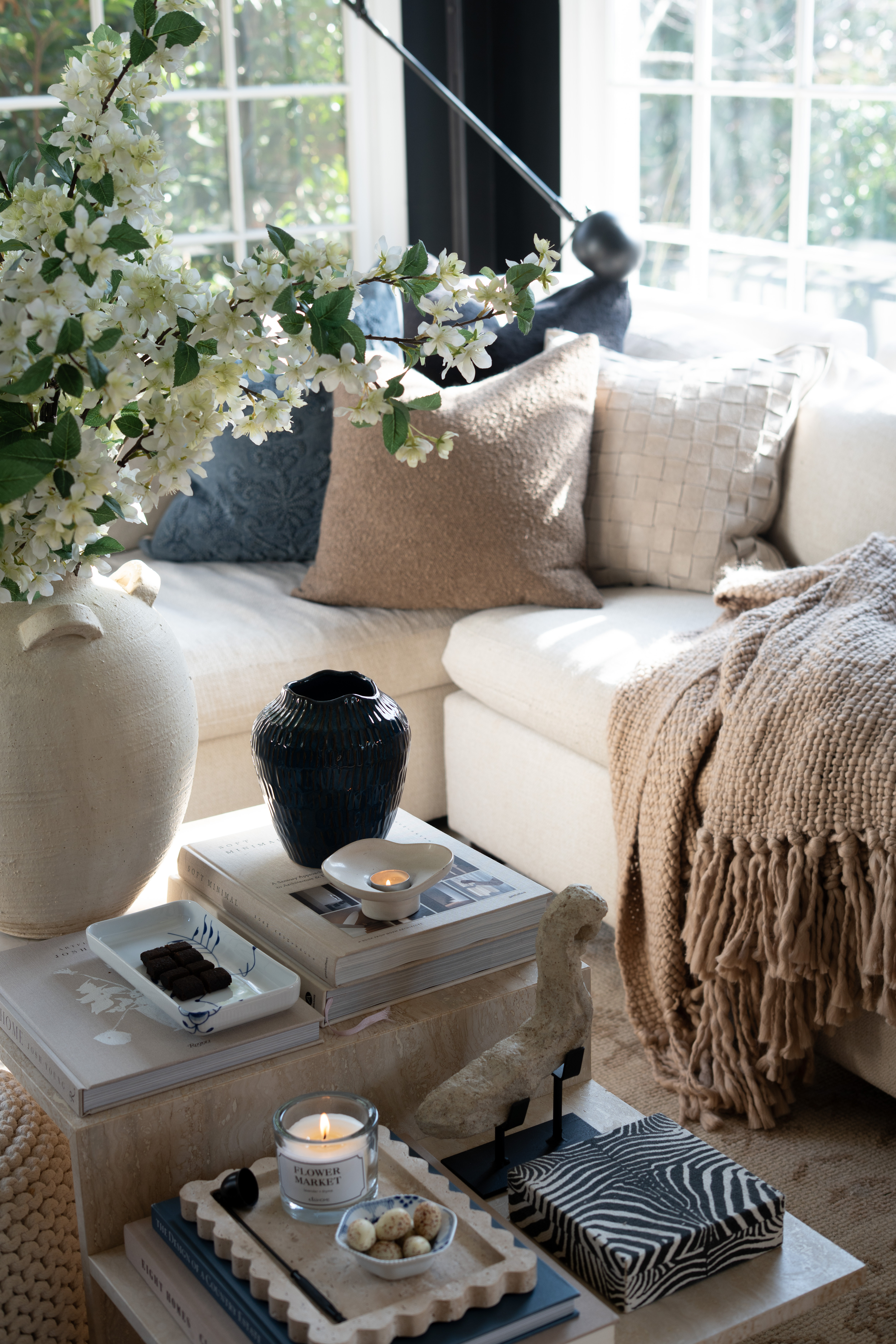 I’m completely swooning over this living room moment. The sunlight pouring through the windows, the oversized vase of spring blossoms, and the layered neutral textures make this space feel calm, cozy, and beautifully styled. The marble coffee table styling and stacked design books just pull everything together. 

 #LTKSpringSale #LTKSeasonal #LTKHome
