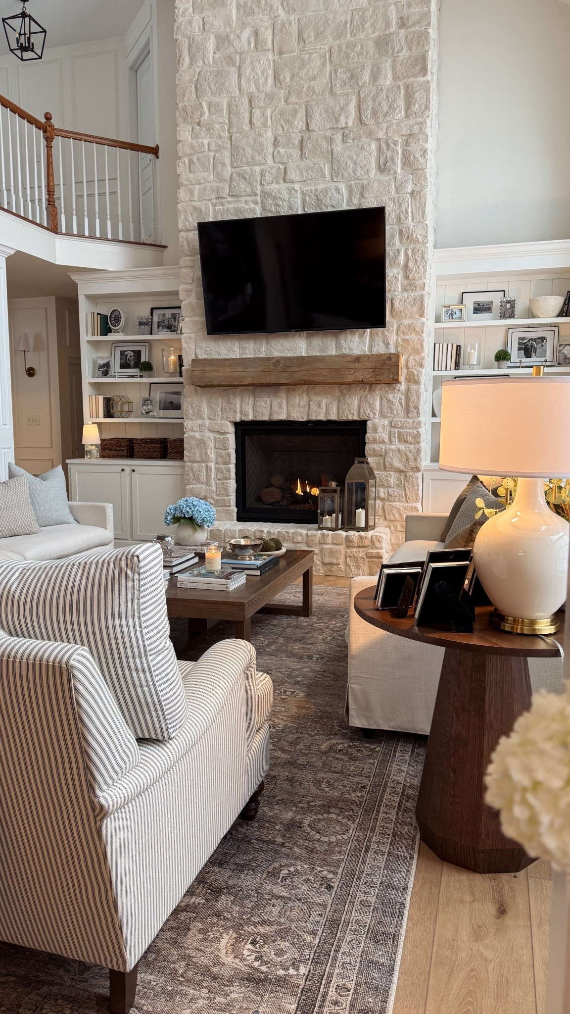 Cozy living room. Nancy meyers aesthetic. Blue and white. Soft coastal. Valentine’s Day . Spring decor. Home organization. Stone fireplace. Amazon hydrangeas. Spring pillow covers. 

#LTKHome #LTKSeasonal #LTKValentine