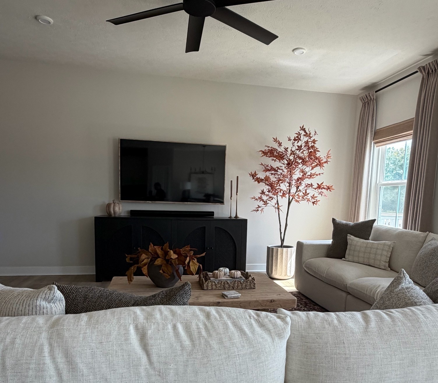 Fall living room styling, coffee table styling, fall magnolia stems, cream sofa, wood coffee table, rectangular coffee table, ￼ black sideboard, black TV sideboard, black TV console, fall tree, maple tree

#LTKSeasonal #LTKHome #LTKSaleAlert