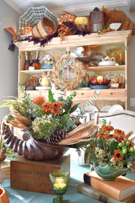 My Thanksgiving table is a mix of old and new. Vintage pottery cornucopias join old turkey planters with fresh flowers and feathers. A vintage verse plaque takes center stage, knowing who is The Giver of all good things. 
Shop the Look here.
See the table closer on Lorabloomquist.com